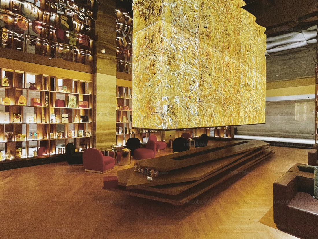 Indian Autumn translucent natural stone panels used as a warm backlit feature in a hotel lobby with timber finishes and lounge seating.