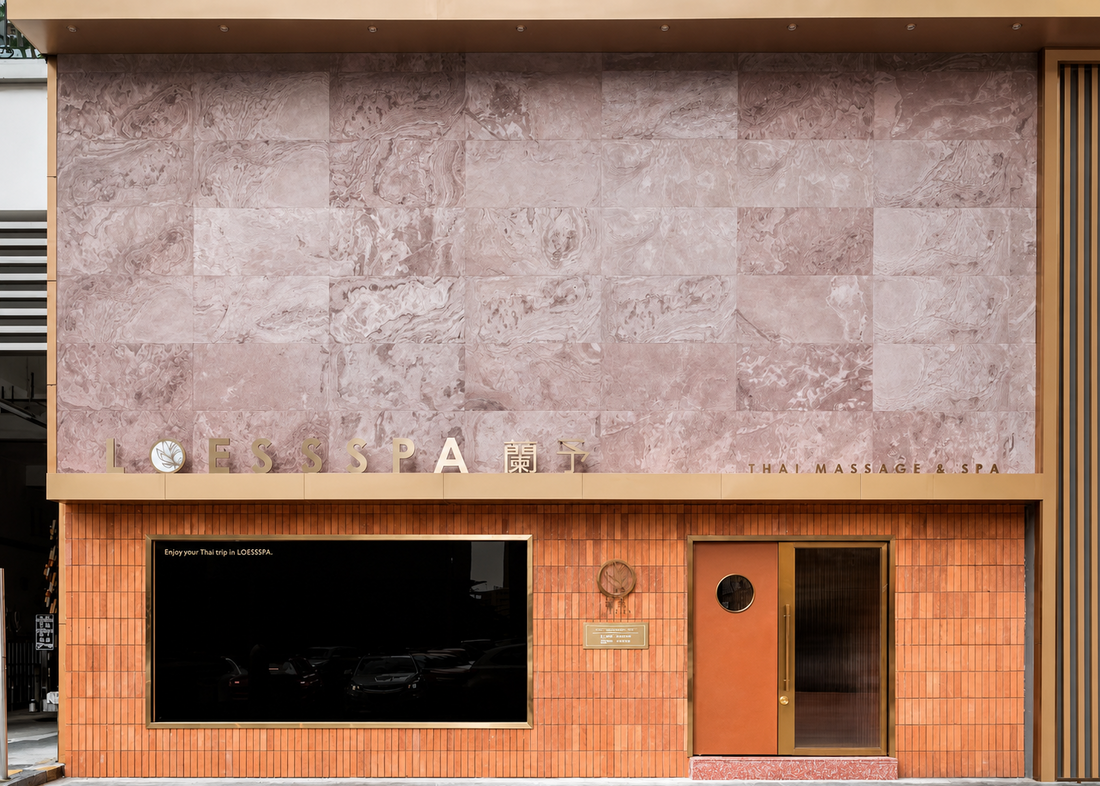 Terra Red natural stone veneer used on a warm commercial facade with brick-red surfaces, timber details and modern storefront design.