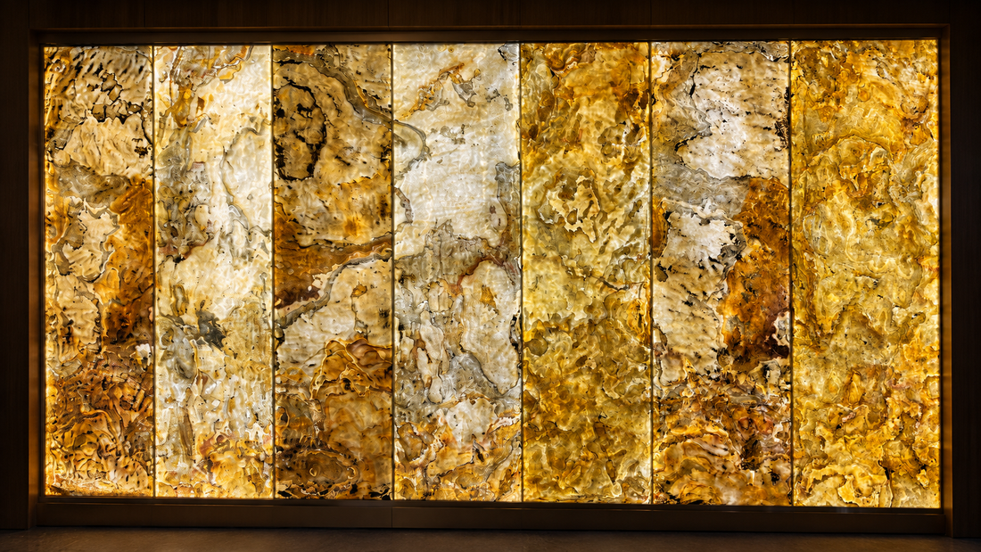 LumiSlate backlit stone panel with real natural stone surface used as a warm illuminated feature wall in a modern dining interior.