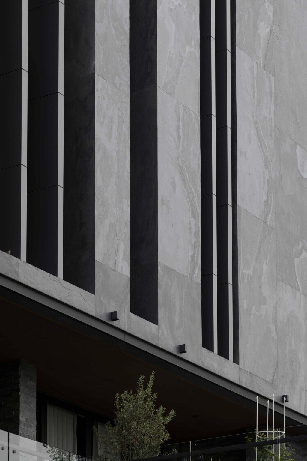 Stone veneer facade with alternating dark and light gray vertical panels
