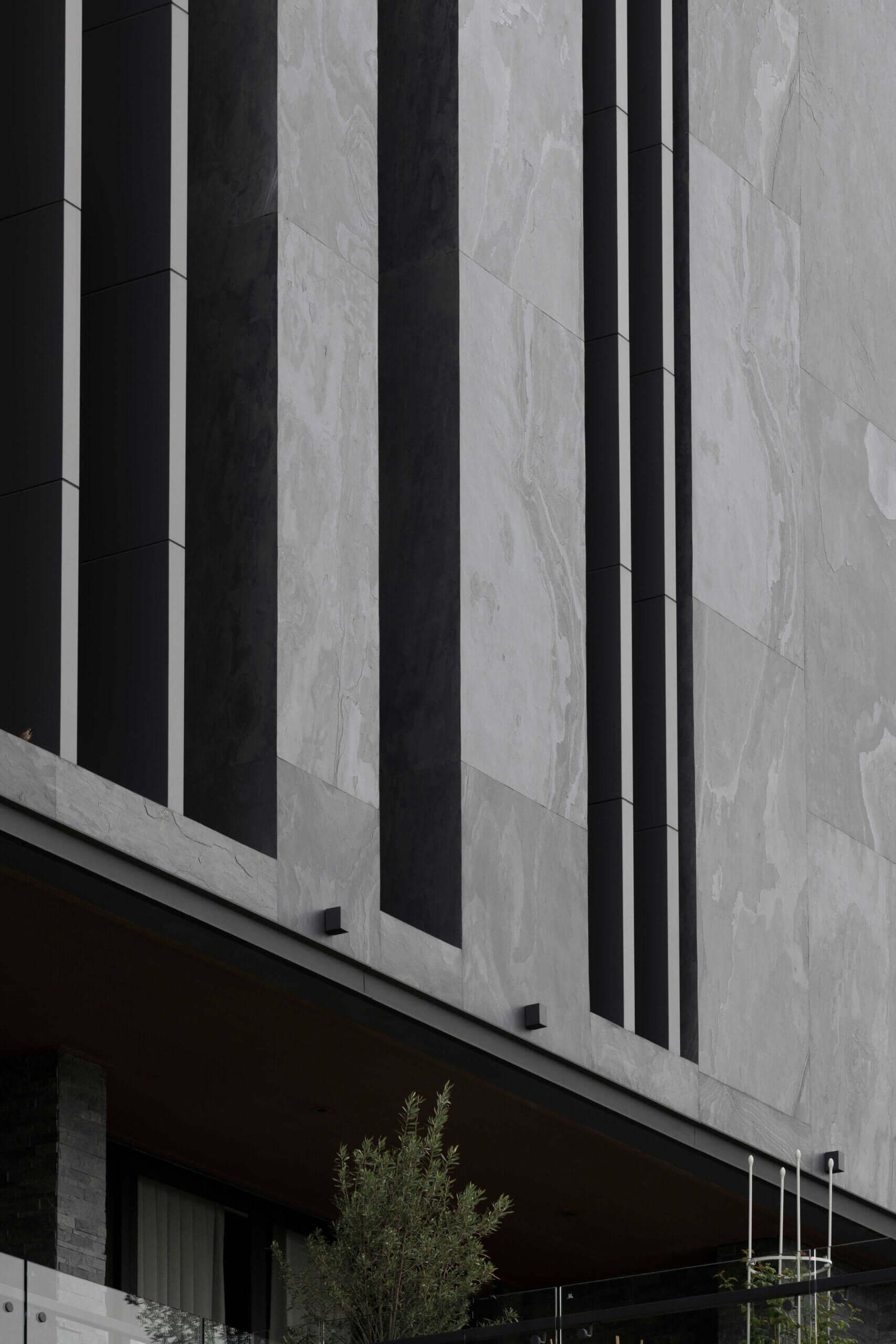 Stone veneer facade with alternating dark and light gray vertical panels