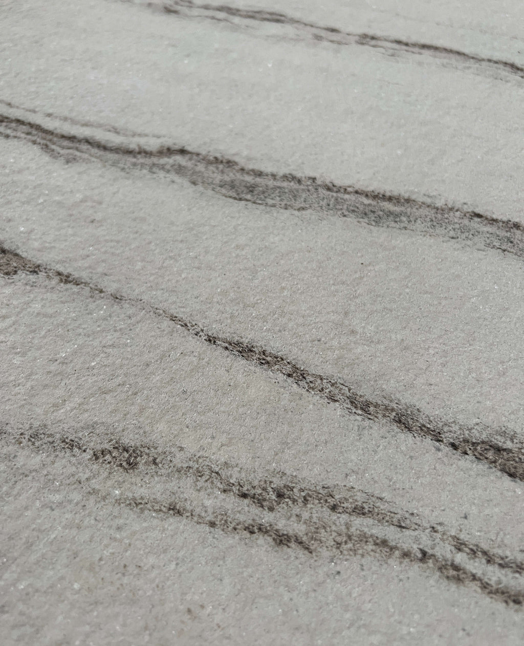 Marble veneer close-up with light gray linear veining on white surface