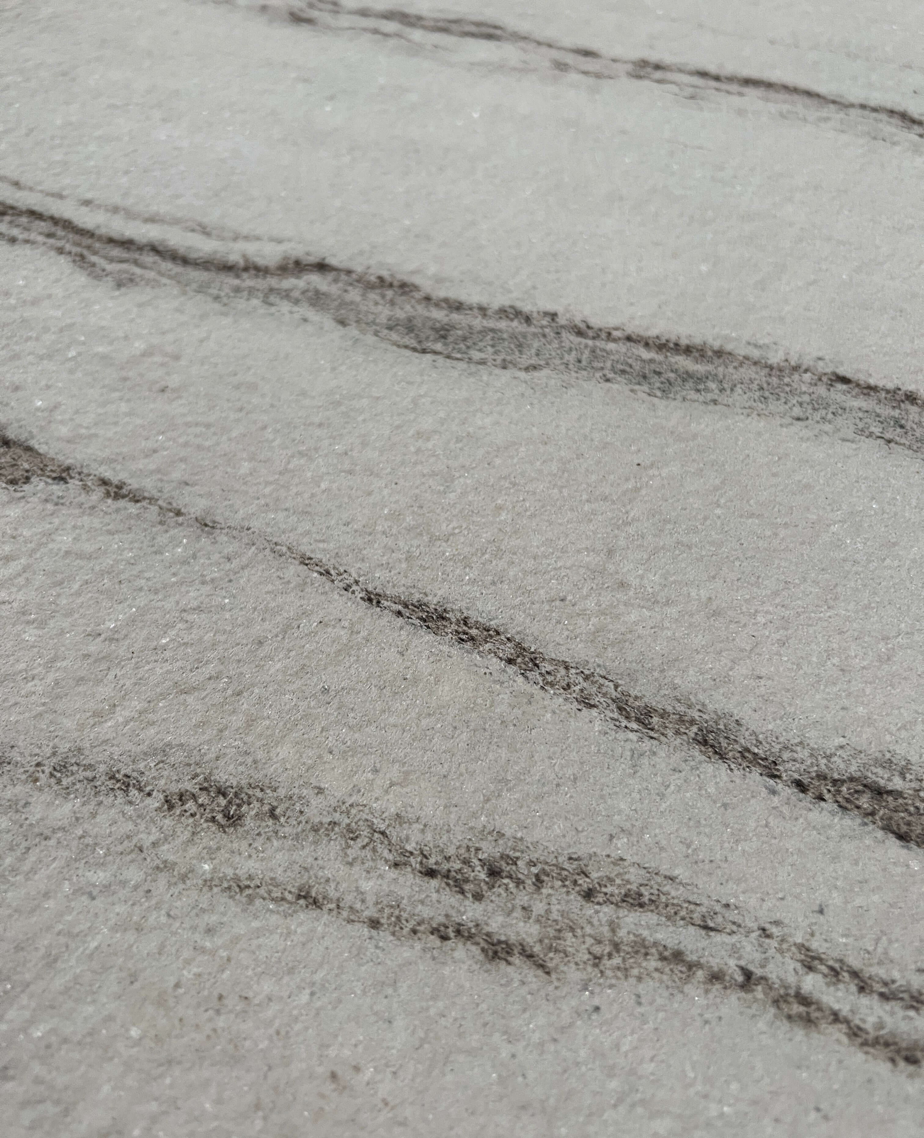 Marble veneer close-up with light gray linear veining on white surface