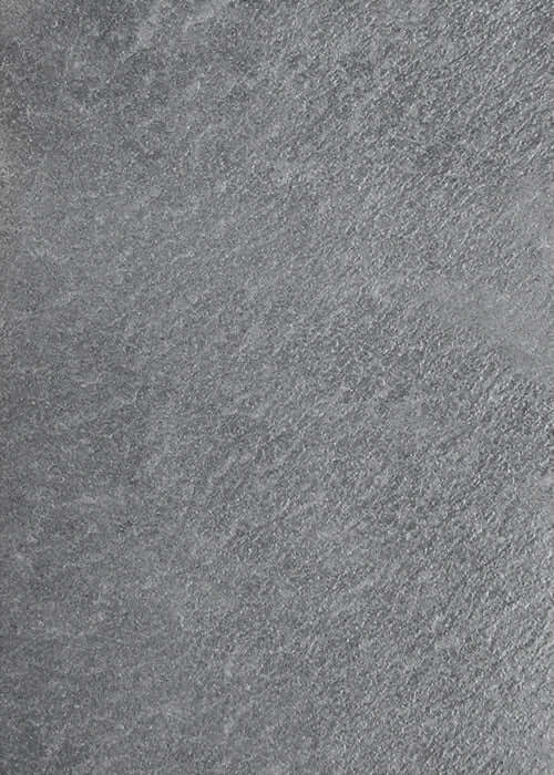 Black natural stone veneer surface with rough, speckled texture