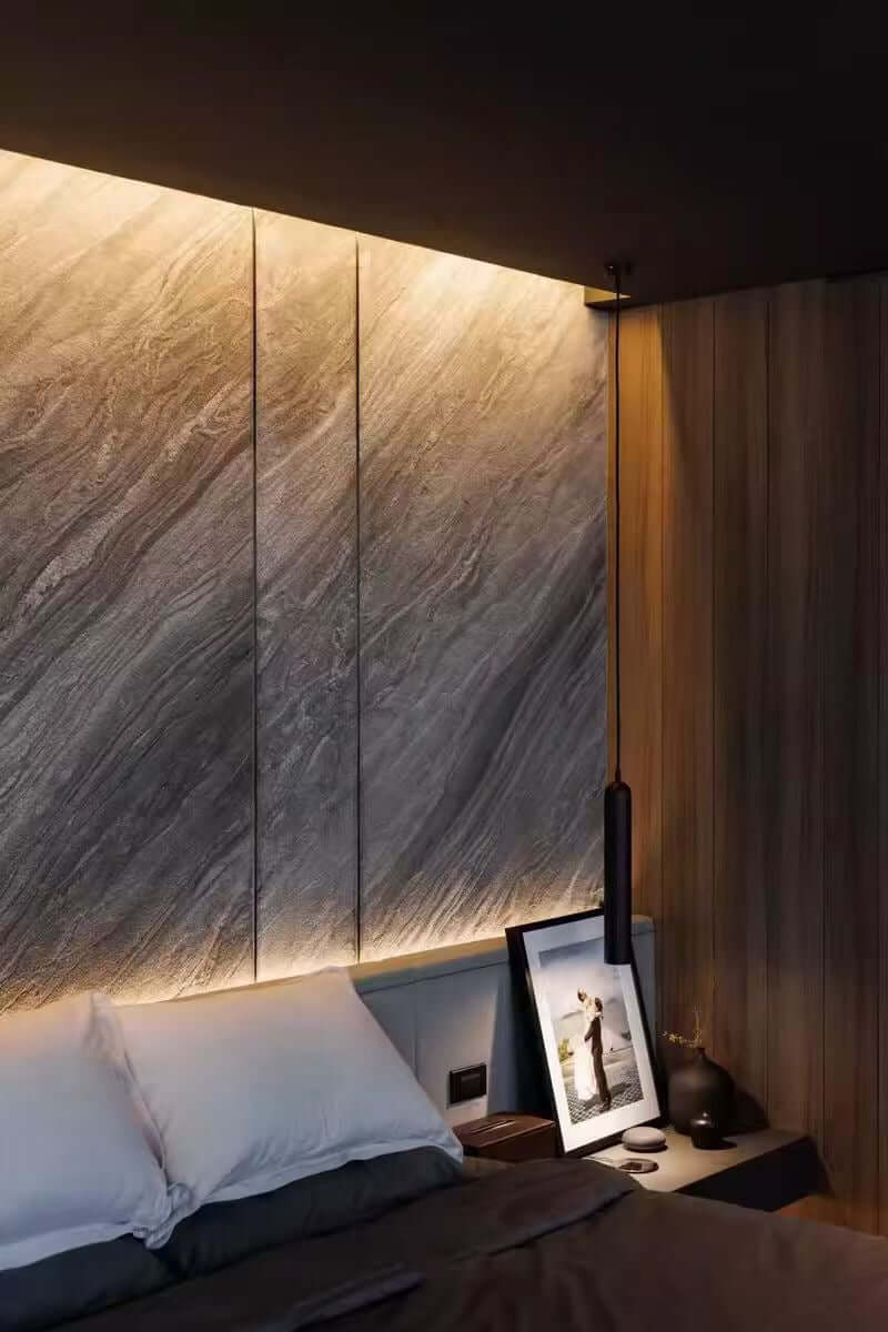 Gray marble veneer wall panels with warm underglow and vertical seams at the corner