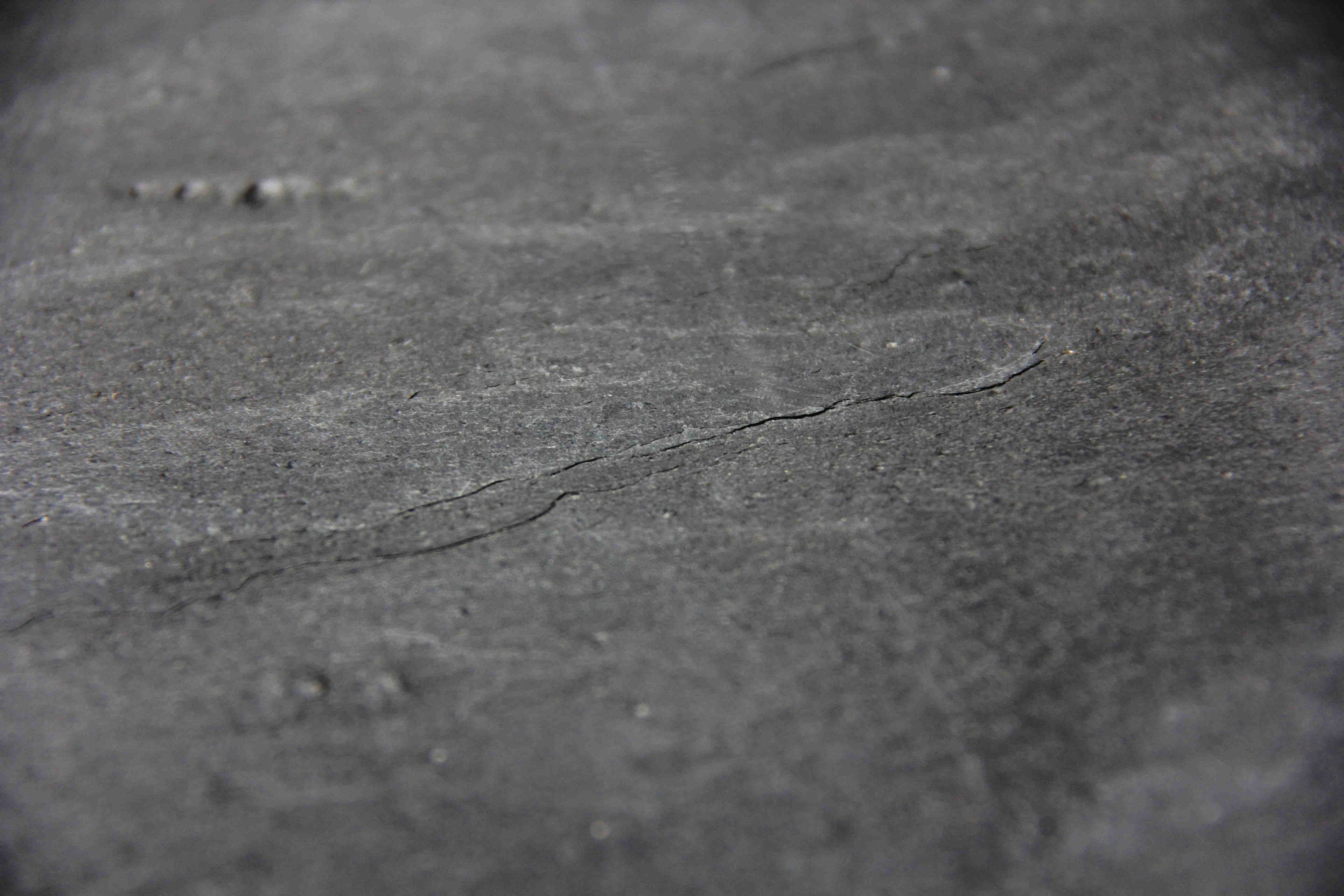 Close-up of black-gray natural stone veneer texture with faint striations