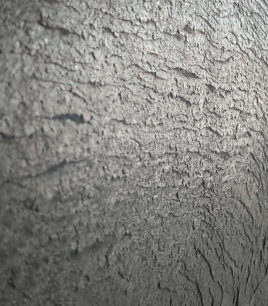 Black natural stone veneer close-up with rough rocky texture