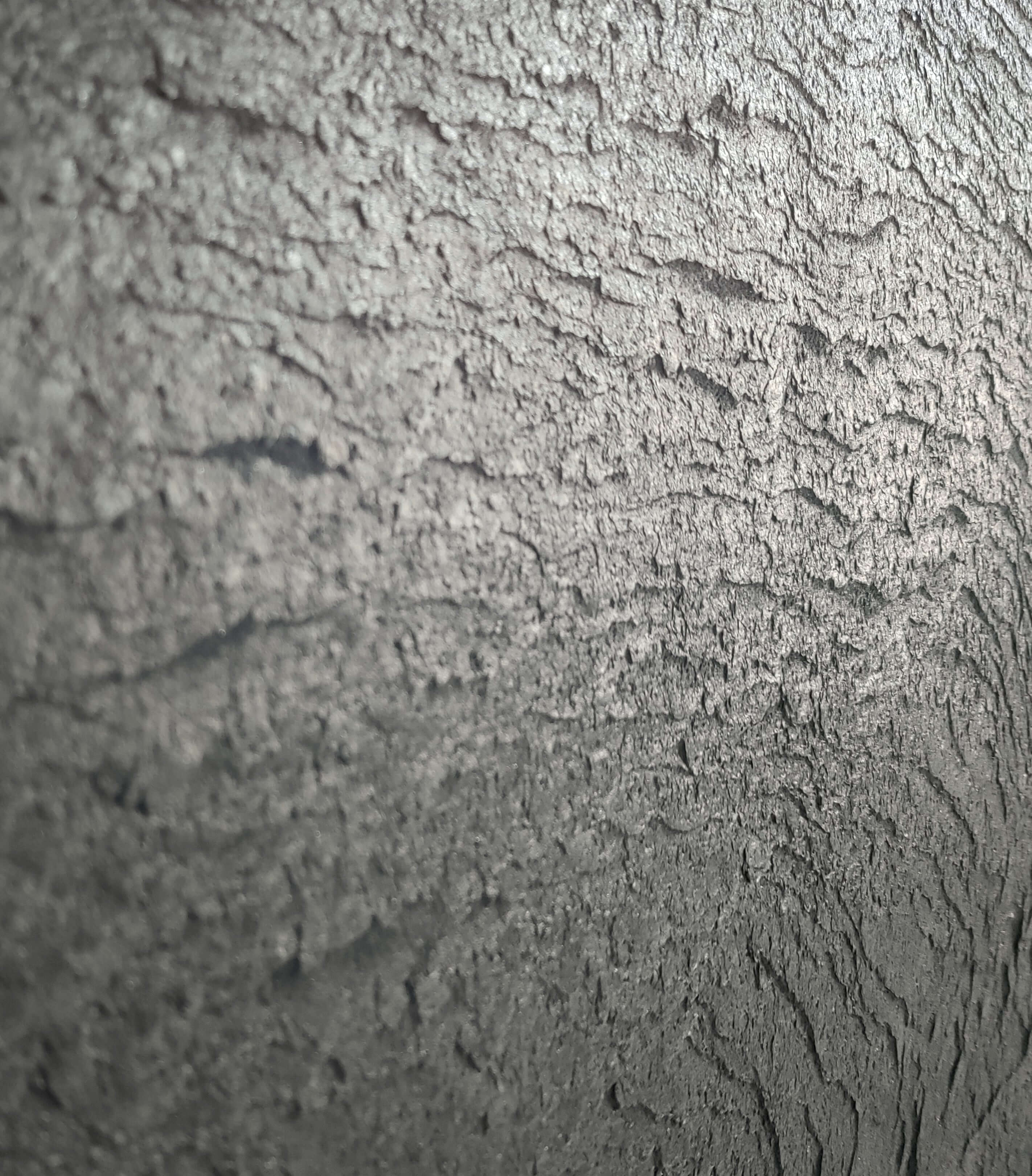 Black natural stone veneer close-up with rough rocky texture