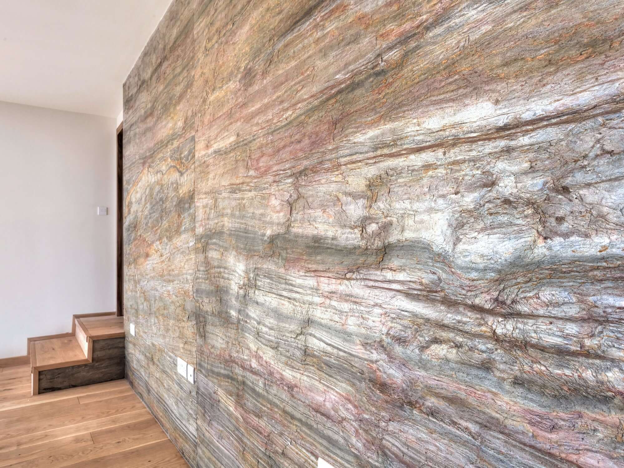 Corner wall covered in blue-gray natural stone veneer with warm copper and tan streaks