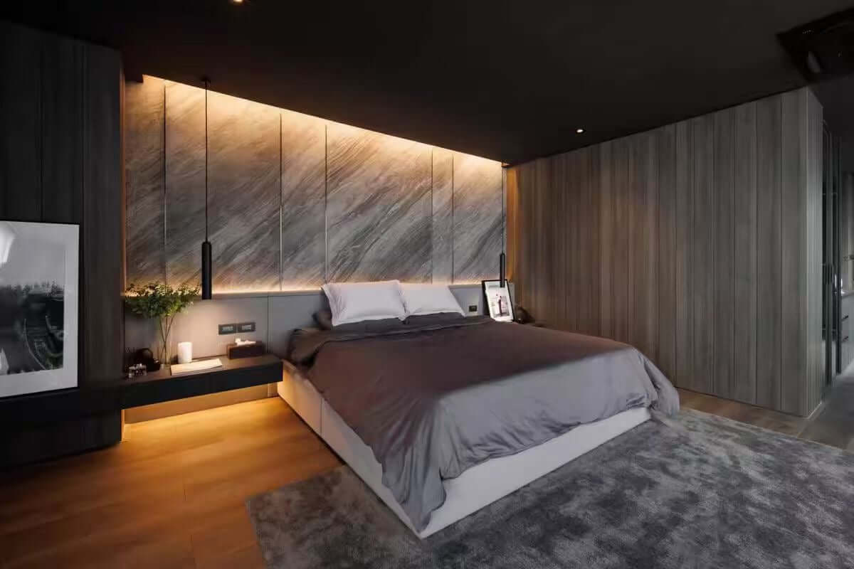 Marble veneer feature wall with warm underlight strip and vertical seams across panels