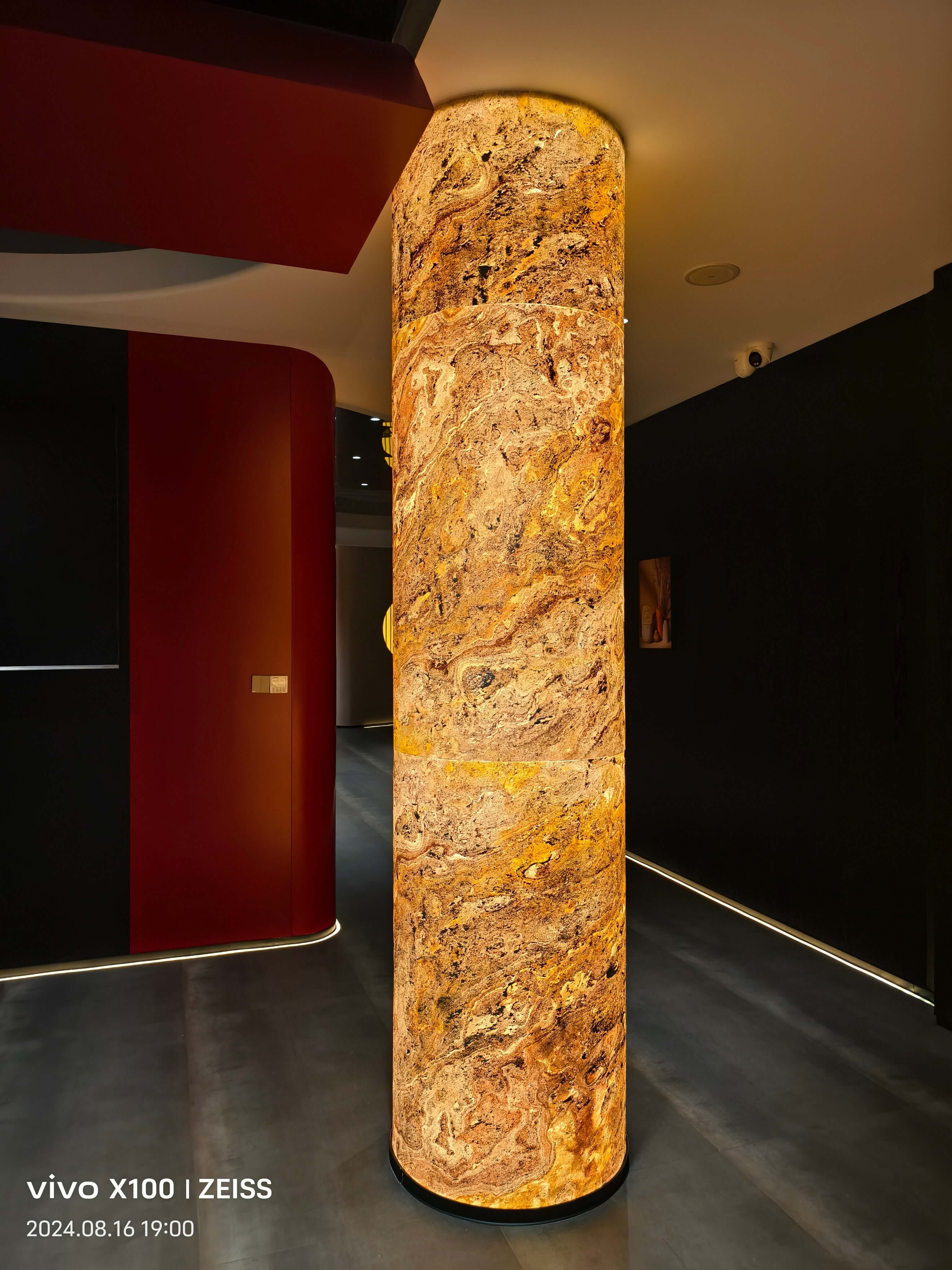 Translucent natural stone light column with swirling amber texture and backlight glow