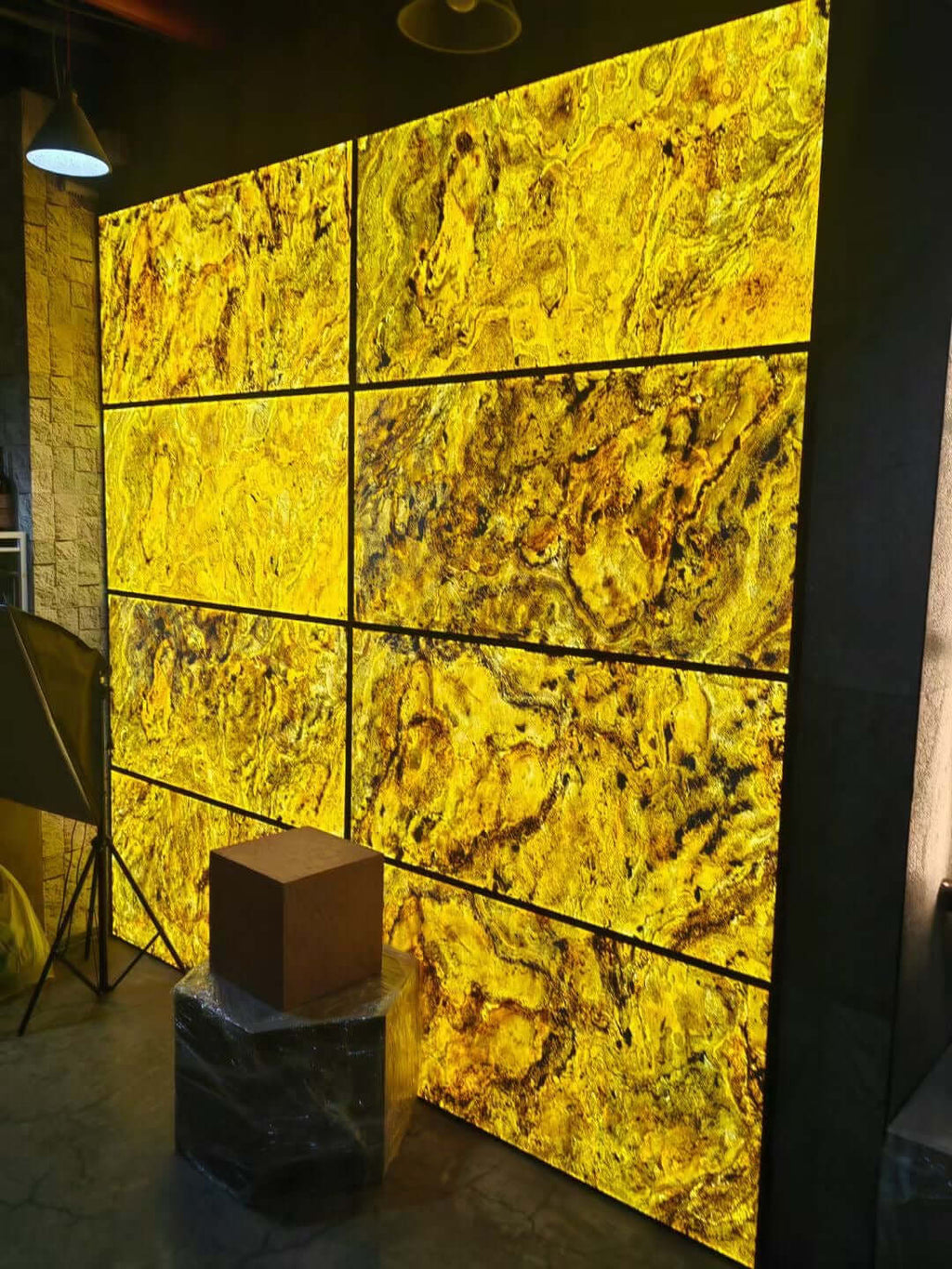 Yellow-gold translucent stone wall panels with grid lines and textured marble veining