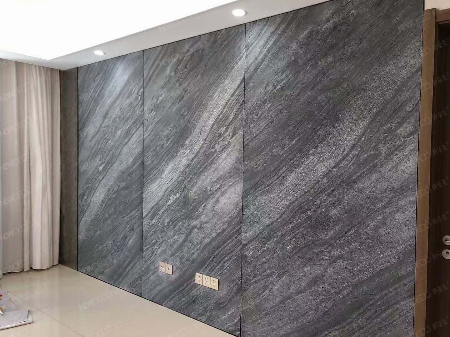 Gray marble veneer wall cladding with vertical panel joints in an interior corner
