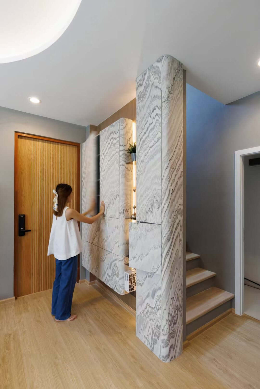 Tall stone veneer panel wrapping a column with white and gray marble veining
