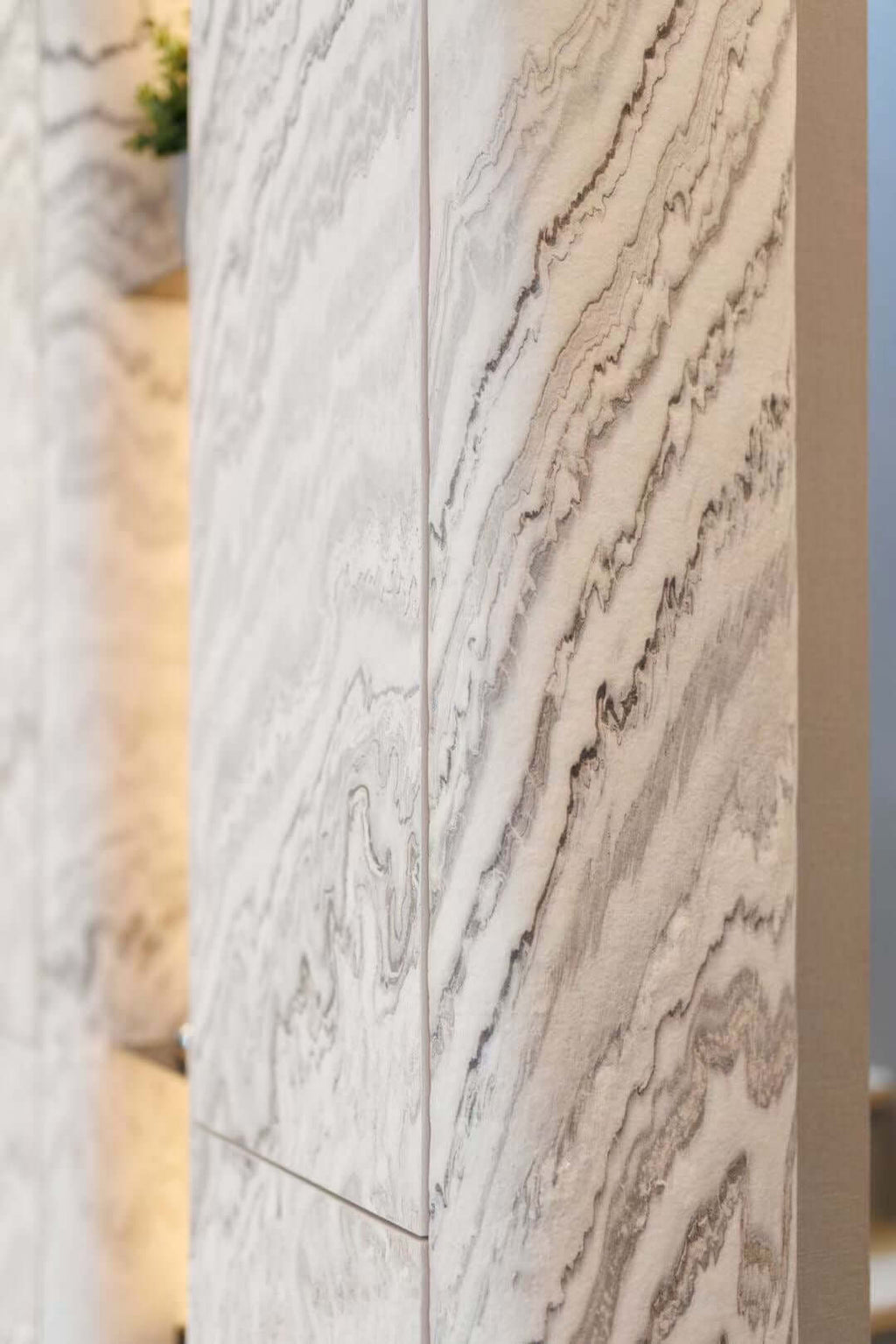 Close-up stone veneer panel with white base and thin gray wavy streaks
