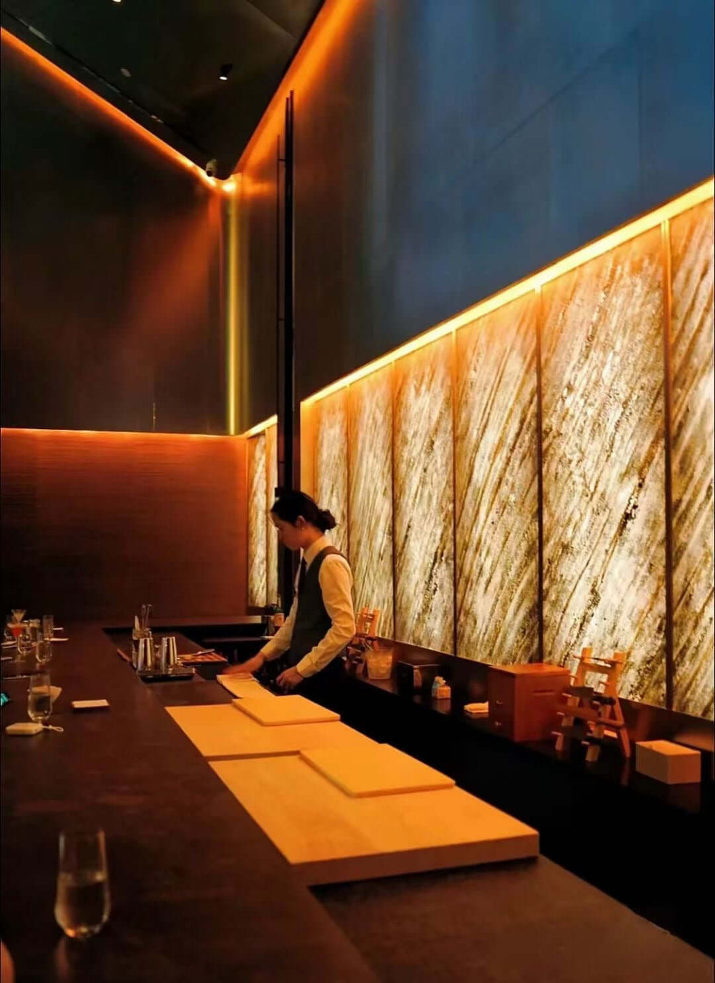 Translucent natural stone sheet wall in sandy tones along a bar seating area