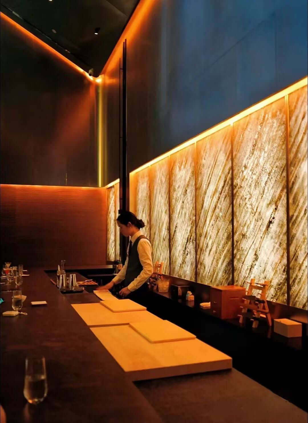 Translucent natural stone sheet wall in sandy tones along a bar seating area