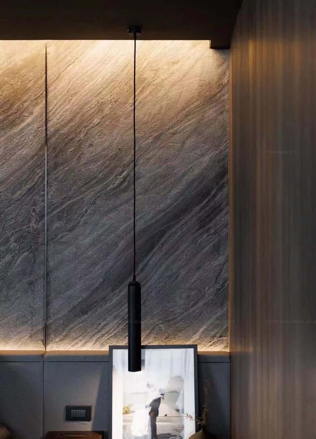 Gray-black marble veneer panels with vertical seams and warm backlit glow along base