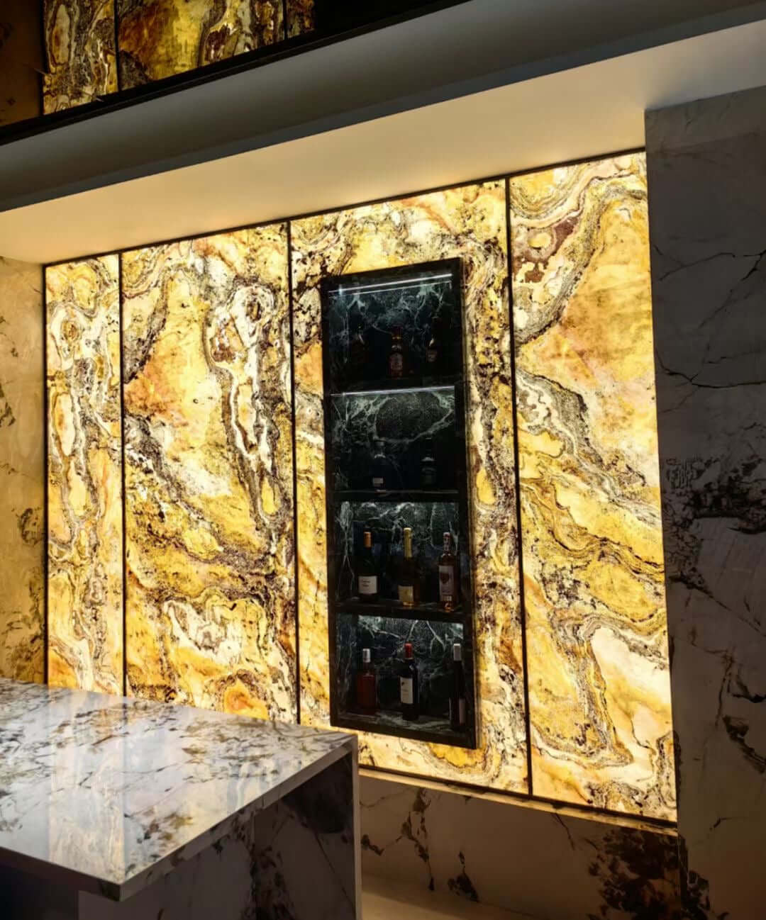 Gold translucent stone wall panels with vertical seams and swirling marbled patterns