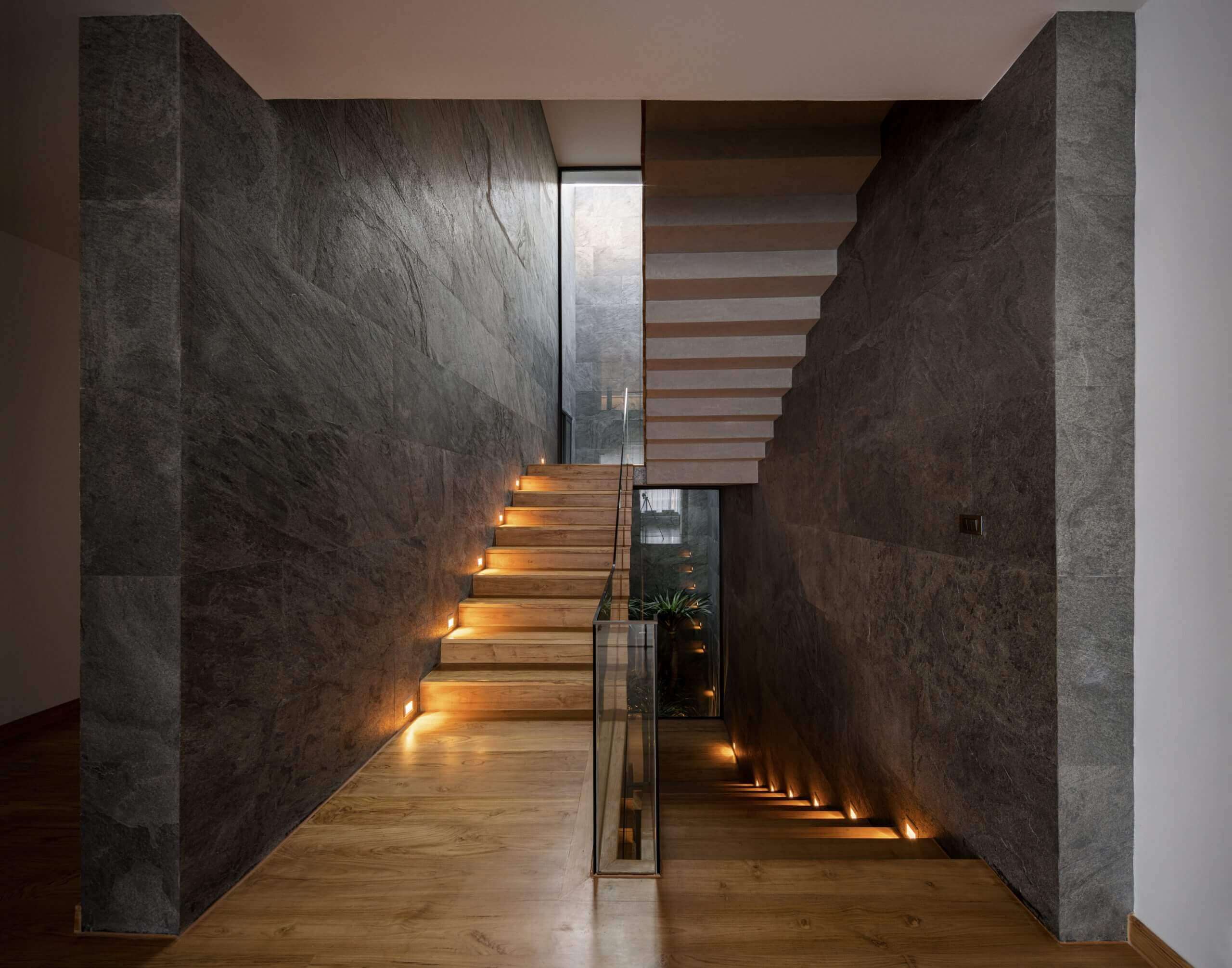Silver grey natural stone veneer on corridor walls with warm lighting and layered texture