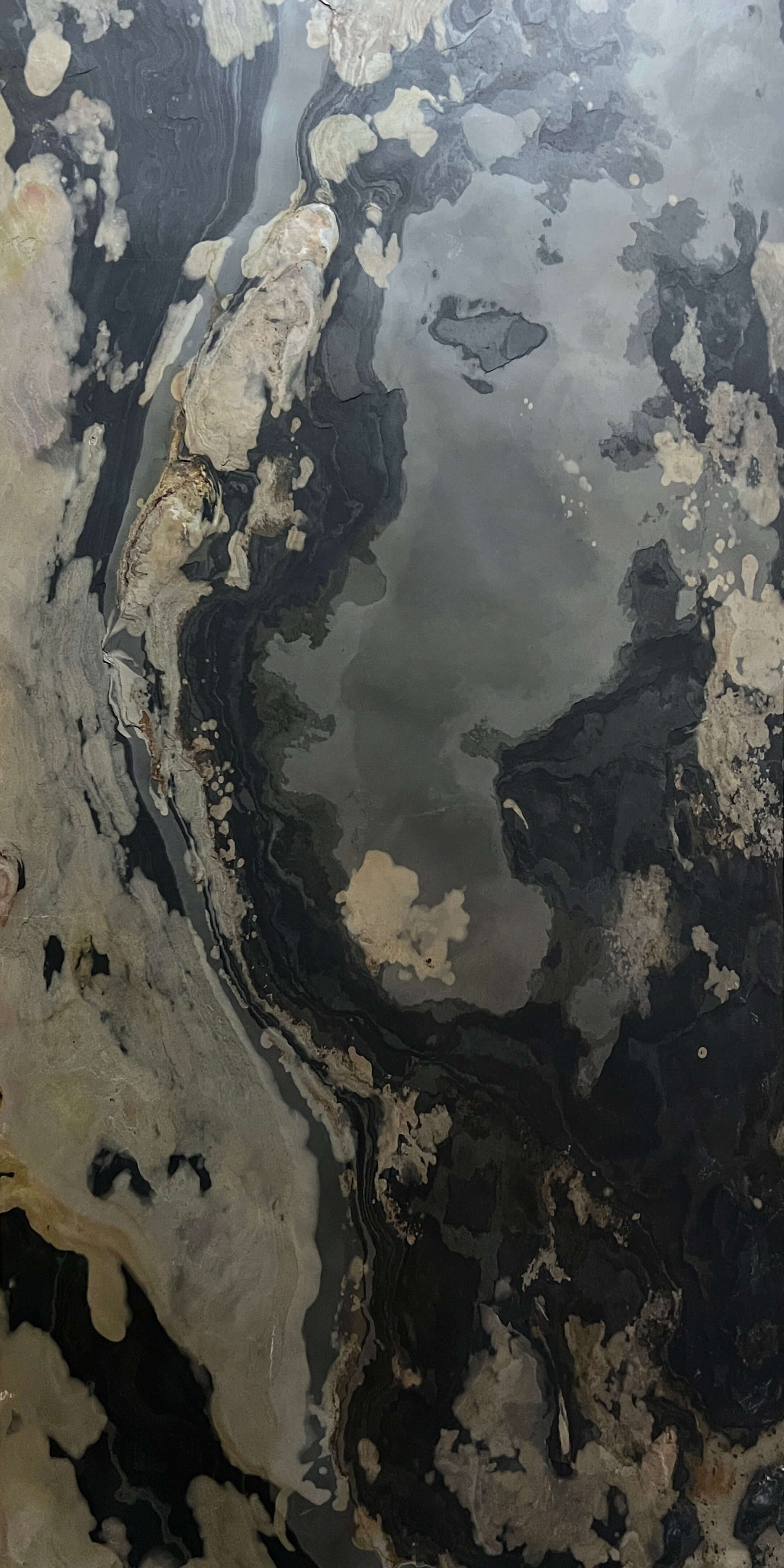 Dark stone sheet with pale cream patches and marbled streak patterns