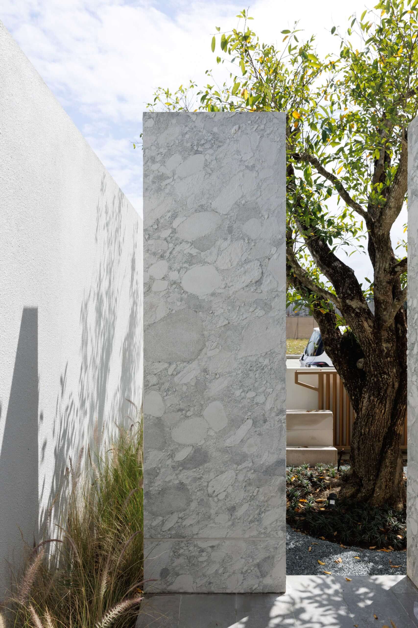 Granite stone veneer slab in light gray with irregular veins on vertical panel surface.