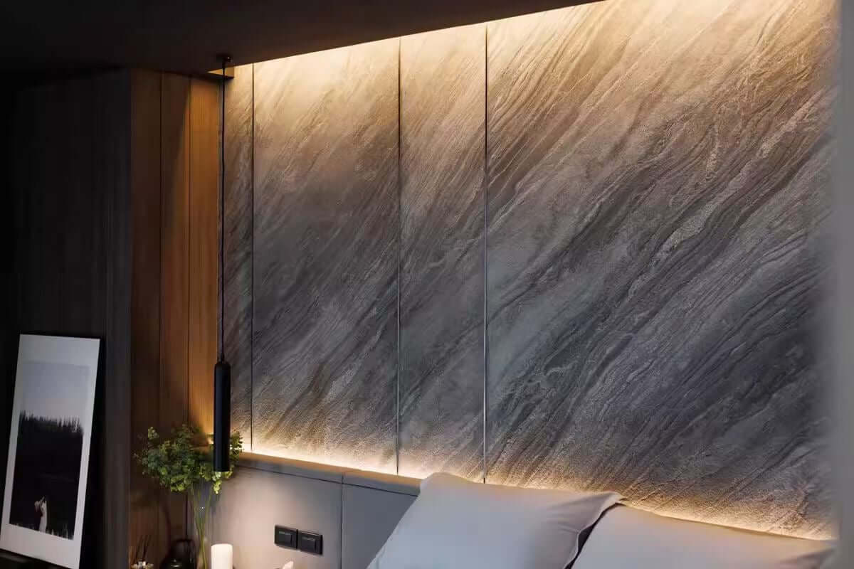 Gray marble veneer wall panels with vertical seams and warm LED accent strip