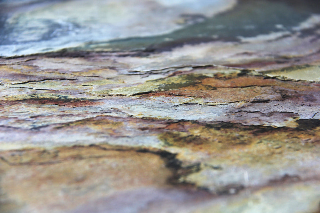 Close-up natural stone veneer with layered gray, beige, and greenish tones