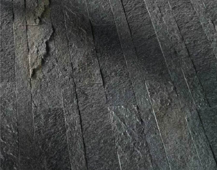 Close-up of dark textured stone tiles with vertical brick-style seams