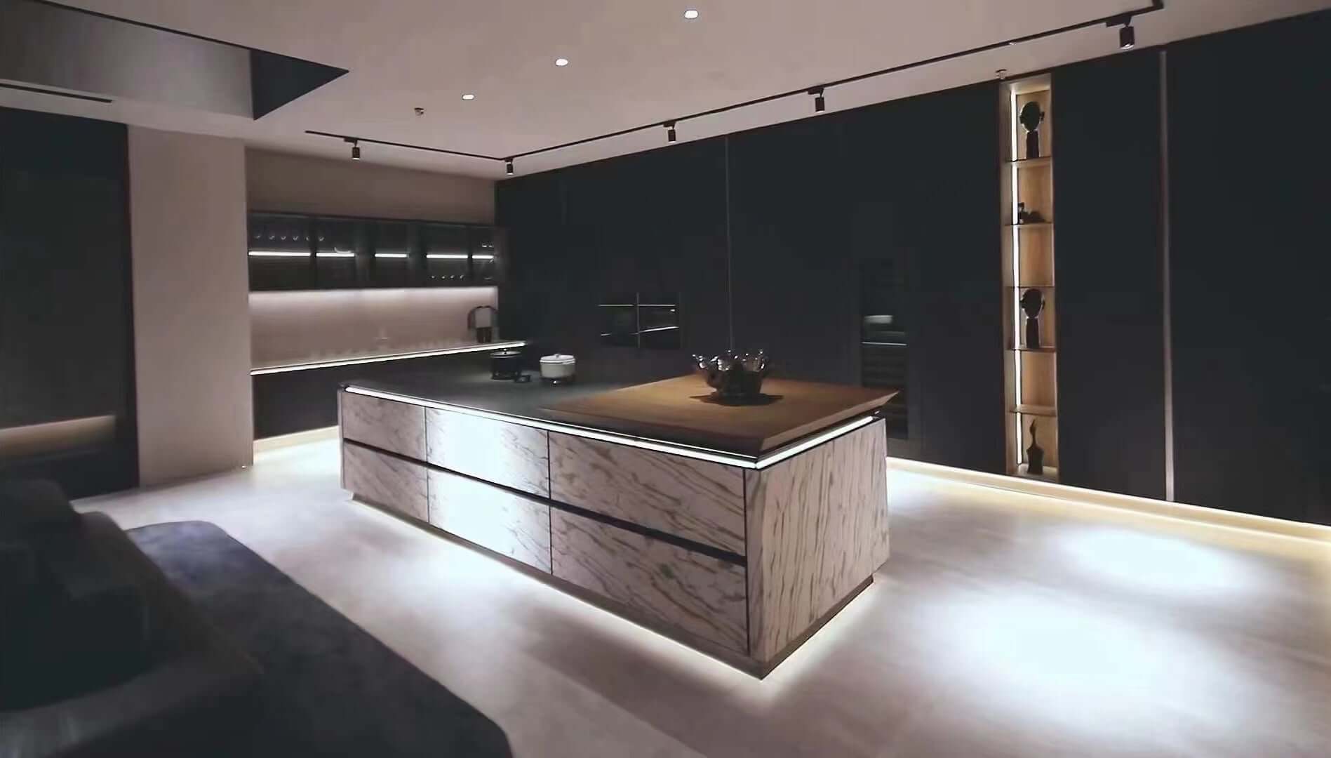 Stone veneer surfaces on a kitchen island and walls with white-gray marble veining