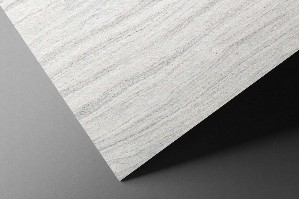 Edge view of white-gray stone veneer board with textured marble-like surface
