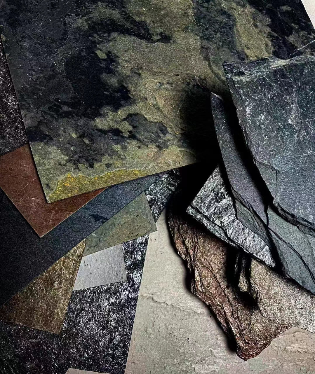 Assorted Nalexible ultra-thin natural stone veneer sample sheets showing real stone colours, textures and flexible layered surfaces.